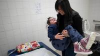 Parent carrying adult with disability onto an adult sized changing table